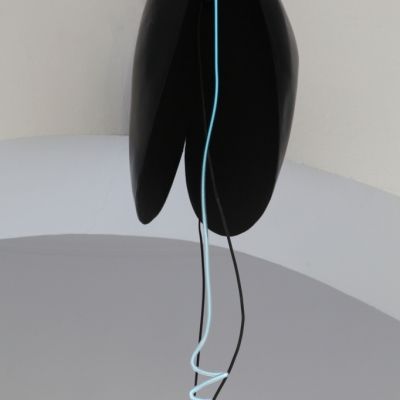 Obiekt wykonany z ciemnego brązu z pionowym neonem, przypominający otwartą muszlę