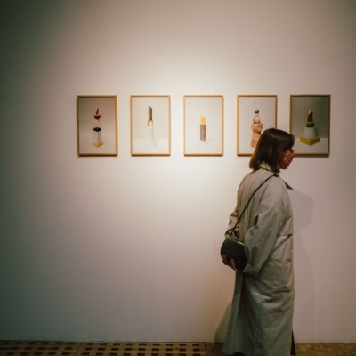 Wernisaż 9 Triennale Młodych, pięc grafik w ramkach prezentowanych na ściania, postać kobiety oglądajacej prace- Zdjęcie udostępnione dzięki uprzejmości p. Piotra Czyża