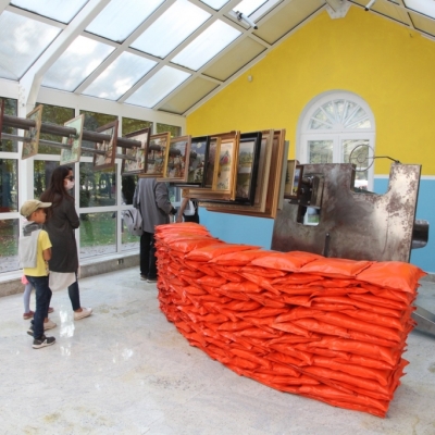 Praca na zdjęciu Armata!, Peter Johansson, 2015, rzeźba, konstrukcja metalowa z tradycyjnymi wyszywanymi obrazami zawierającymi motyw czerwonych szwedzkich domów, worki z piaskiem