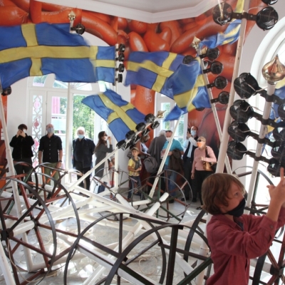 Publiczność oglądające pracę Cała naprzód!mobilną grupę rzeźb z powiewającymi szwedzkimi flagami
